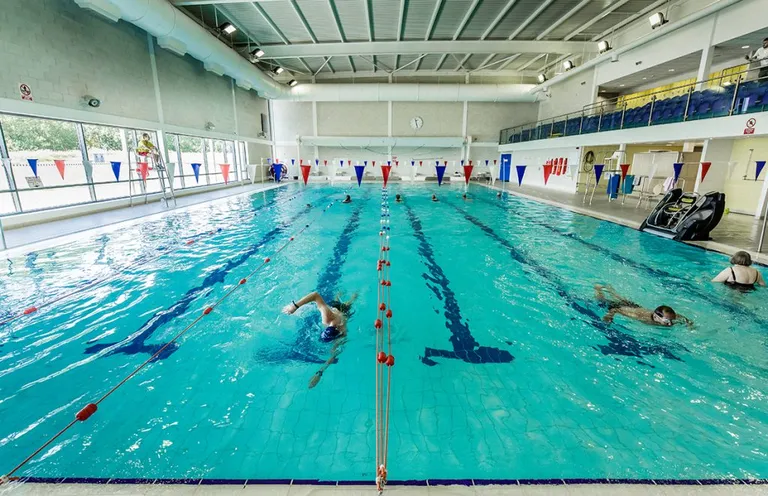 A swimming pool with swimmers approaching the end of the pool. The pool is part of Downham Health and Leisure Centre who are clients of analytics4energy, a 4energy group company.